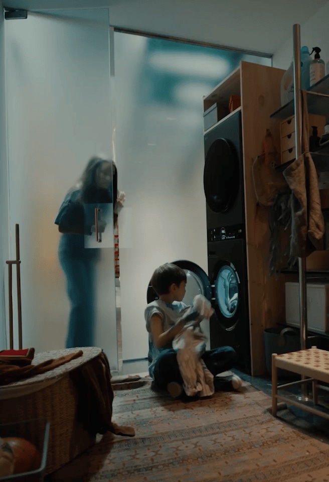 Una madre y su hijo usan juntos una lavadora LG AI, girando el dial para activar AI Wash. Un hombre usando la laptop LG gram aparece en la misma secuencia.