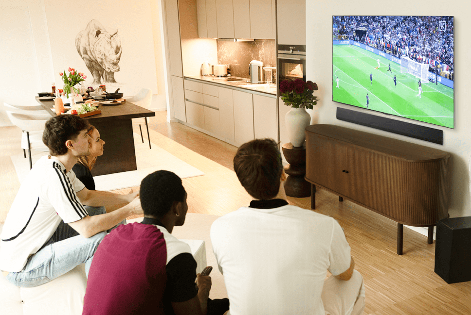 Un grupo de personas reunidas frente al LG OLED evo TV para ver el partido de fútbol.
