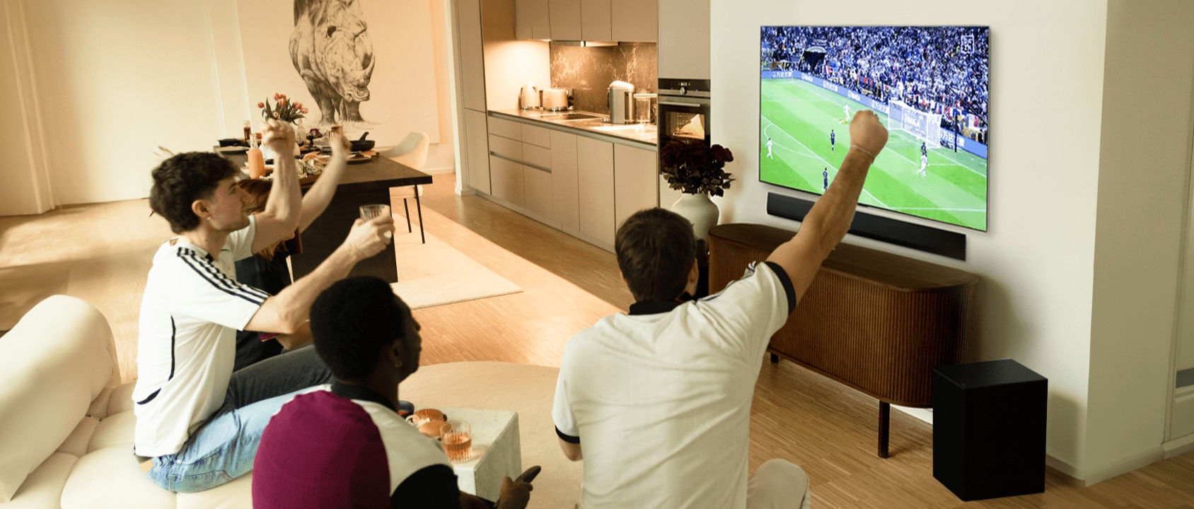 Un grupo de personas animando y disfrutando del partido de fútbol con el LG OLED evo TV.