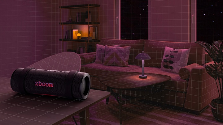 En una habitación iluminada en rojo se colocan un sofá negro, una otomana negra y un sillón negro. En el frente, xboom Grab está colocado encima de una mesa redonda negra.