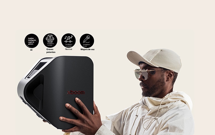 will.i.am con traje blanco y gorra blanca sostiene el xboom Stage 301 con ambos brazos en la cara.