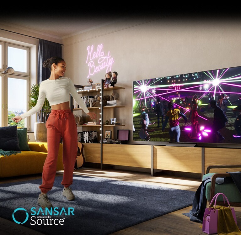 Una mujer está bailando en su habitación mientras ve un concierto en el metaverso de ?Sansar? en el televisor.