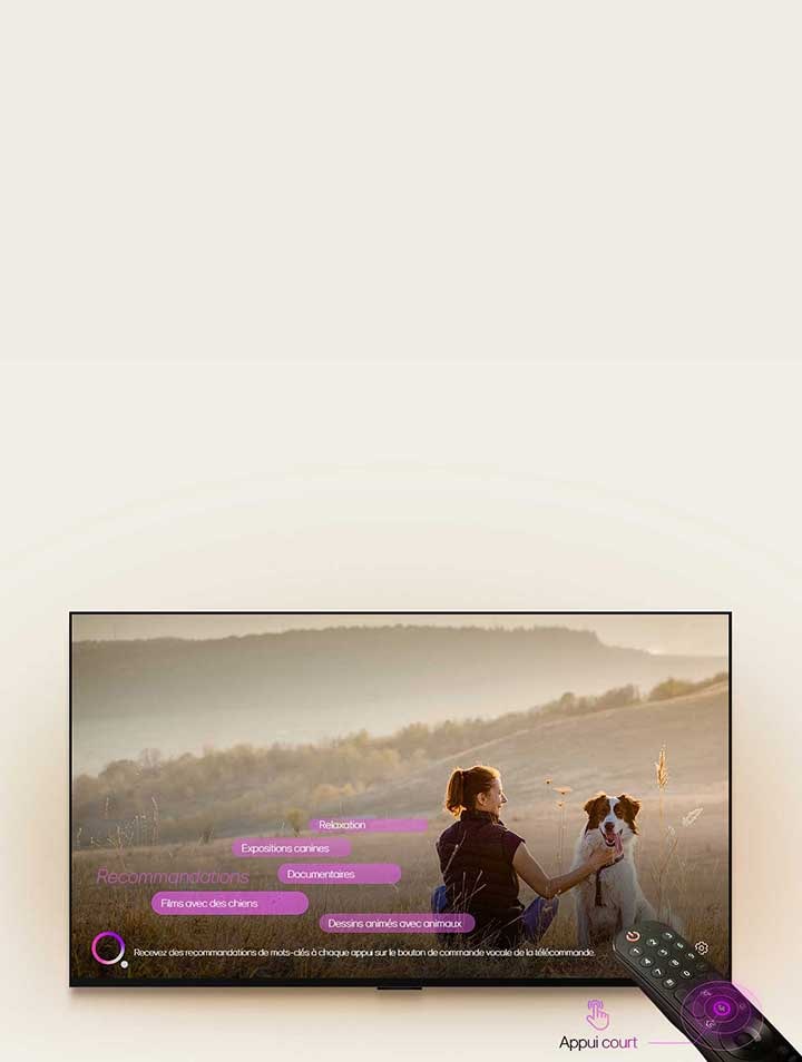 Une LG TV montre l’image d’une femme et d’un chien dans un champ. En bas de l’écran, le texte?: ??Recommande de nouveaux mots clés chaque fois que vous appuyez sur le bouton de micro sur la Télécommande?? est affiché à c?té du graphique de cercle rose-violet. Les barres roses affichent les mots clés suivants?: Films avec des chiens, concours canin, documentaire, relaxation, animations avec animaux. Face à la LG TV, la Télécommande Magic LG est pointée vers le téléviseur avec des cercles concentriques violet fluo autour du bouton du micro. à c?té de la télécommande, un graphique d’un doigt appuyant sur un bouton et le texte ??Appuyer brièvement?? est affiché.
