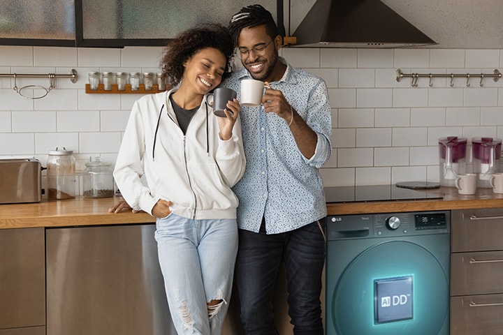 Le couple tenant la coupelle se trouve à c?té de la machine à laver. Une line IA sort de la machine à laver avec le logo AIDD dessus et détecte les vêtements.