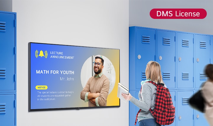 Cette image montre un élève qui regarde du contenu sur un écran d’affichage dynamique dans le hall de l’école. La notification affichée indique?: ??MATHS POUR LA JEUNESSE?? (session spéciale pour les mathématiques), demandant aux élèves de se rassembler dans la salle de conférence.