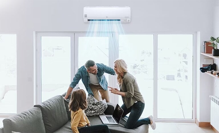 Installés dans leur salon, tous les membres d’une famille sont heureux de profiter de la ventilation fra?che de leur climatiseur.