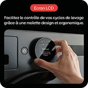 Une machine à laver posée dans une salle de bain, connectée à des tuyaux visibles avec un mur carrelé en arrière-plan.