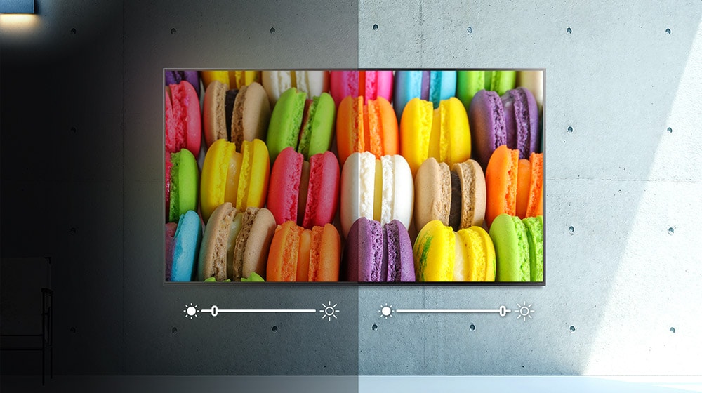 Un écran, moitié dans l’obscurité, moitié dans la lumière, présente une image de macarons colorés. La luminosité est ajustée de chaque c?té.
