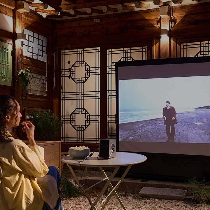 La vidéo montre un client dans une maison d'h?tes hanok regardant un film, écoutant de la musique et savourant son petit-déjeuner avec des appareils LG.