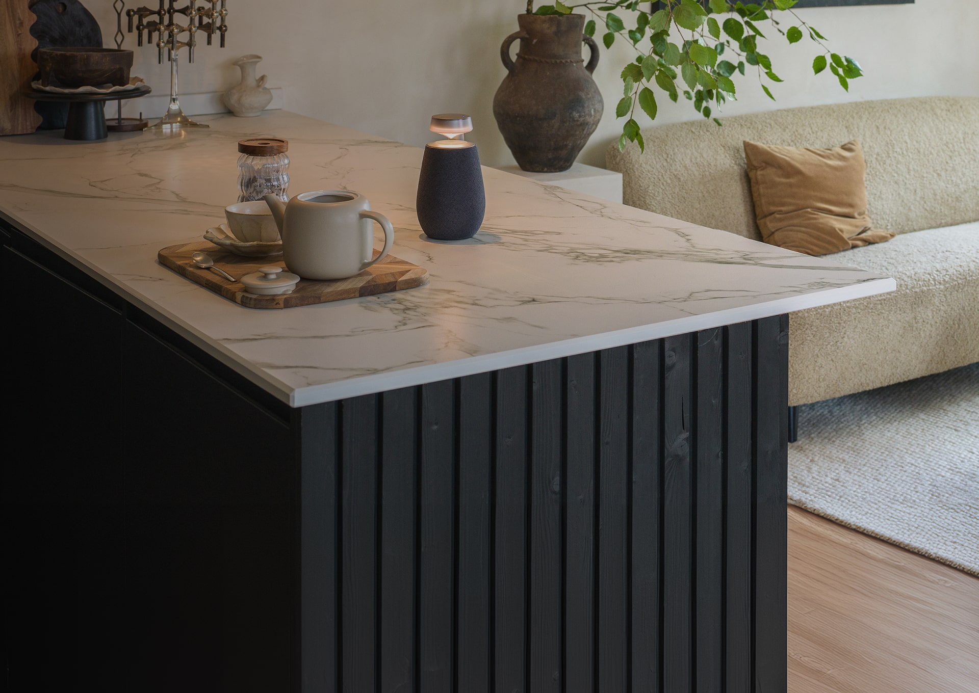Un haut-parleur sans fil LG Xboom XO2T avec Mood Lighting est placé à c?té d'un service à thé sur le bar à manger.