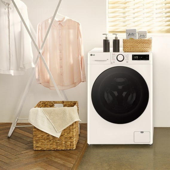 Des chemises propres et fra?chement lavées sont étendues sur un séchoir à c?té de la machine à laver LG.