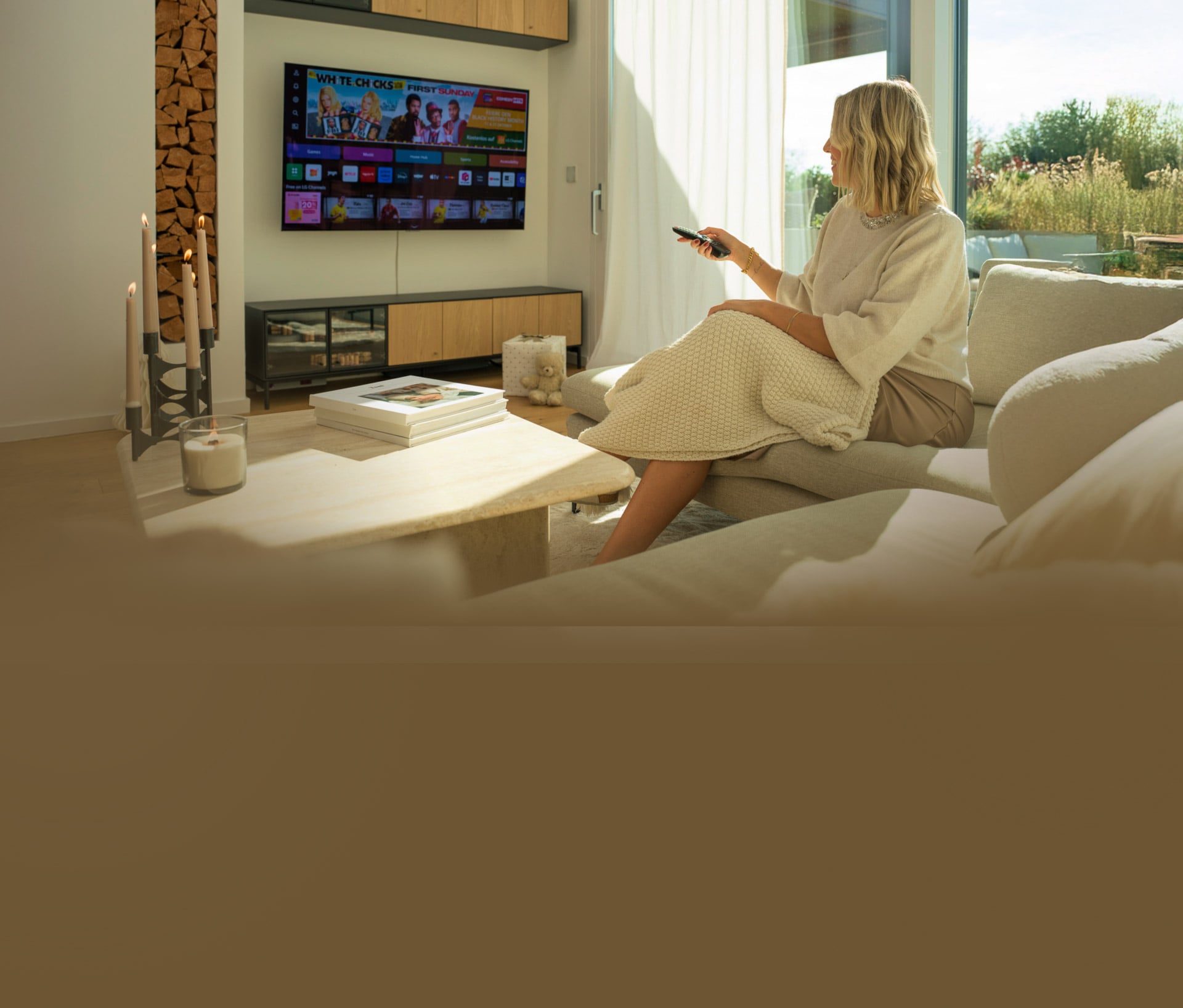 Une femme se détend sur un canapé dans un salon moderne, utilisant une télécommande pour contr?ler le LG OLED G4 4K Smart TV.