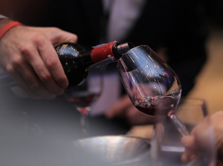 James Suckling is pouring wine into the wine glass.