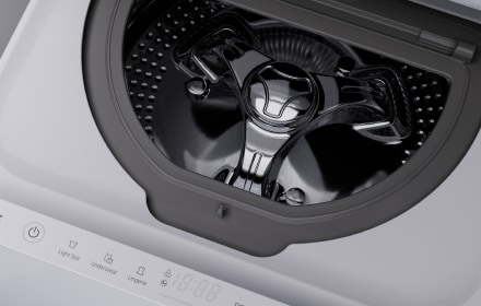 Image showing the top right section of the LG Signature Washing Machine. Part of the machine door, Quick Circle Display panel, and detailed white enamel body are shown.