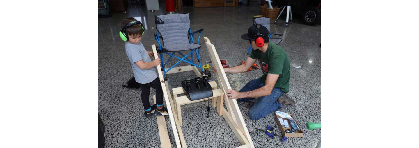 Rick Kelly and his son in the act of building their at-home racing simulator