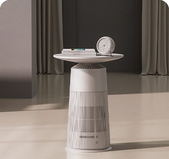 Modern white side table with a round clock and books, placed in a minimalist room with beige curtains and a dark wall behind.