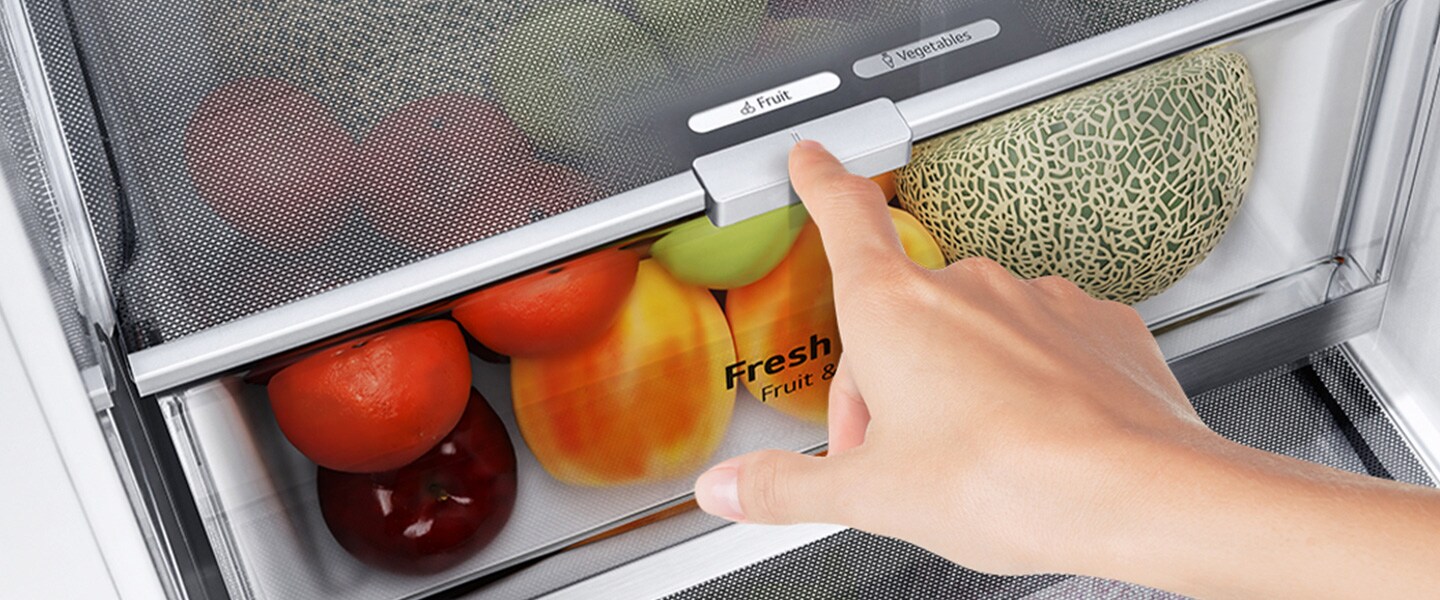The bottom drawers of the fridge are filled with colorful fresh produce. An inset image magnifies the control lever to choose the optimal humidity level to keep produce fresh.