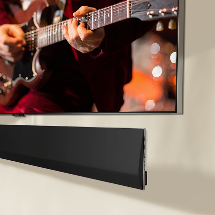 An angled perspective of the bottom of an LG OLED TV and LG Soundbar.
