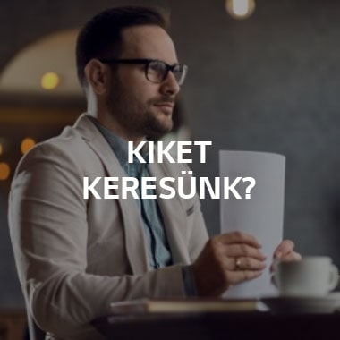 Egy férfi ül az asztalnál, és egy k?teg papírt tart