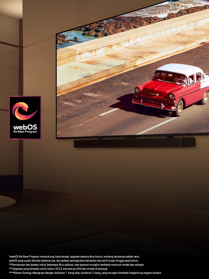 LG QNED TV dan Soundbar dipasang di dinding dalam ruangan dengan pencahayaan redup. Di TV, ditampilkan kendaraan berwarna merah di jalan. Logo "webOS Re:New Program" ada di dalam gambar. Penafian sebagai berikut: “webOS Re:New Program mendukung total empat upgrade selama lima tahun, ambang batasnya adalah versi webOS yang sudah diinstal sebelumnya, dan jadwal peningkatan bervariasi dari akhir bulan hingga awal tahun.” “Pembaruan dan jadwal untuk beberapa fitur, aplikasi, dan layanan mungkin berbeda menurut model dan wilayah.” “Braket Synergy dilengkapi dengan dudukan 1 tiang atau dudukan 2 tiang, yang mungkin berbeda tergantung negara/produk.”