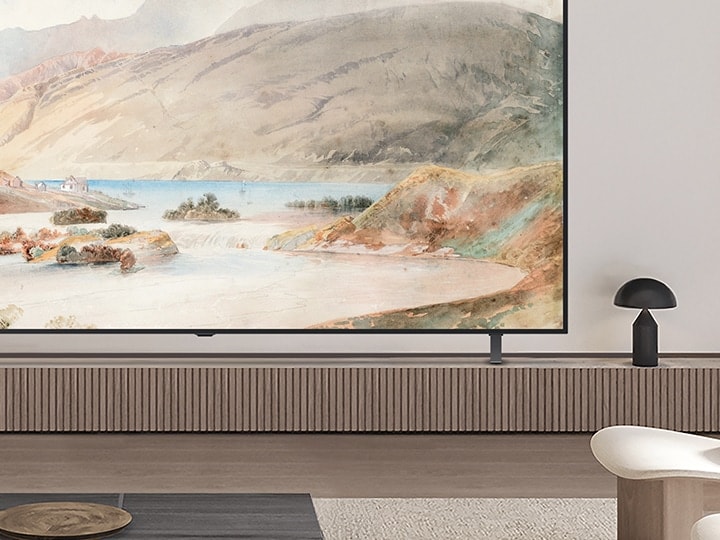 Primo piano di un angolo di un LG OLED TV in un salotto. è su un supporto e si può notare come il modello sottile si abbini bene al design degli interni. 