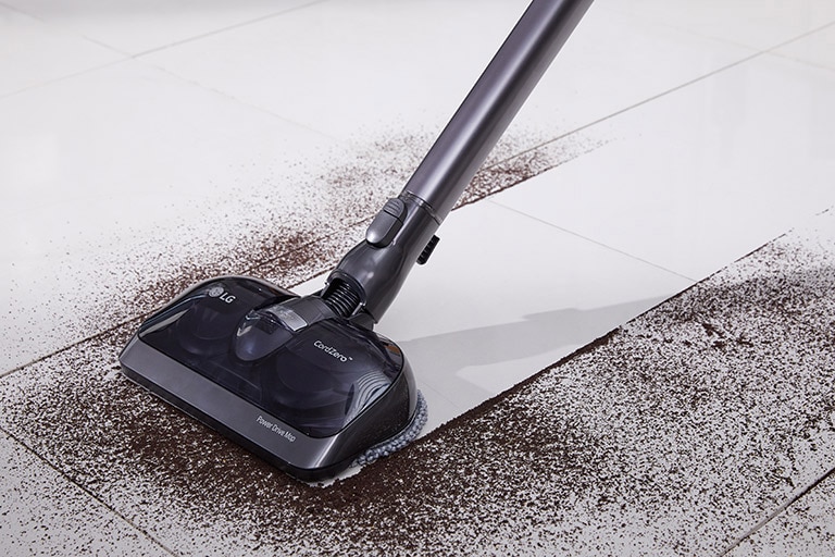 Aspirapolvere LG CordZero pulisce efficacemente sporco scuro su pavimento bianco in ceramica.