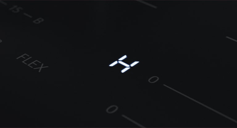 Dettaglio del led con la lettera &quot;H&quot; che indica che il piano cottura è ancora molto caldo.