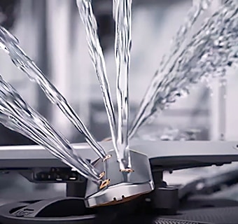  Sistema QuadWash di una lavastoviglie LG con spruzzi di acqua per una pulizia efficiente dei piatti.