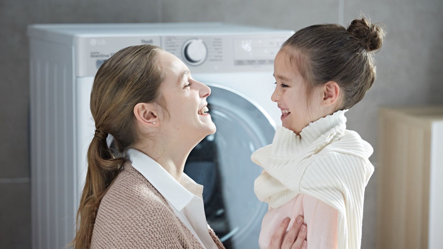 Lavare la lana in lavatrice: immagine di una mamma e una bambina che fanno il bucato in lana con la lavatrice LG.