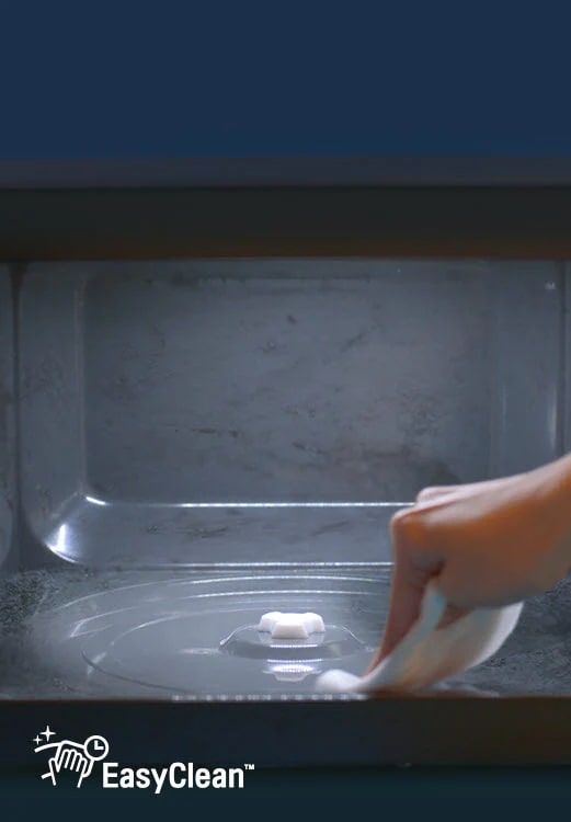 Mostra una mano che pulisce la superficie interna di LG NeoChef?