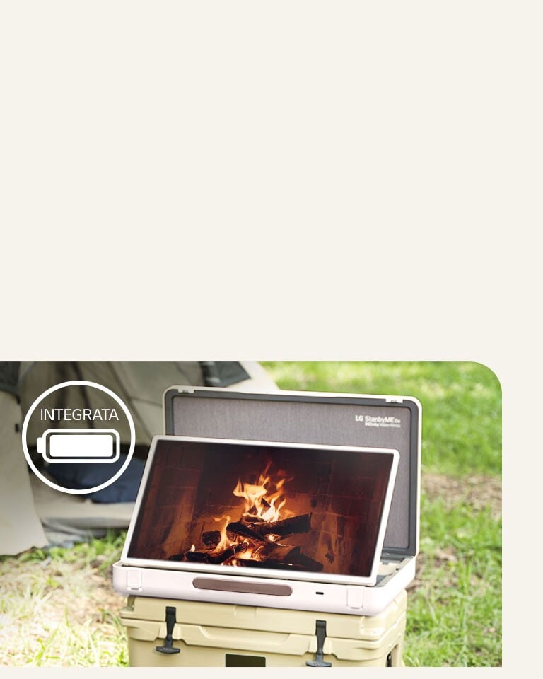 Foto di LG StanbyME Go posizionato di fronte a una tenda. Sullo schermo c'è un tema rilassante che mostra un fuoco scoppiettante. In alto a sinistra c'è l'icona della batteria integrata,