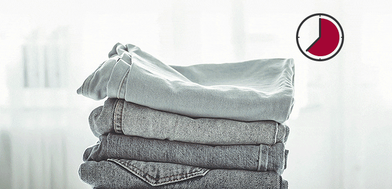  Pila di jeans piegati con un'icona di orologio nell'angolo in alto a destra che mostra il passare del tempo.