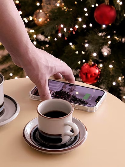 上に攜帯電話を置いて、充電機能を使用しています。その隣にはコーヒーカップを置いて、テーブルのように使用しています。