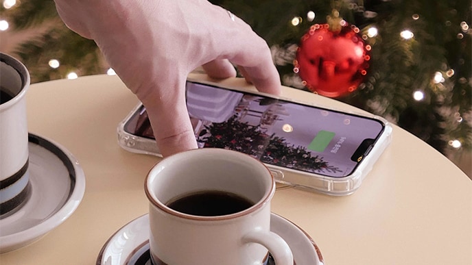 上に攜帯電話を置いて、充電機能を使用しています。その隣にはコーヒーカップを置いて、テーブルのように使用しています。