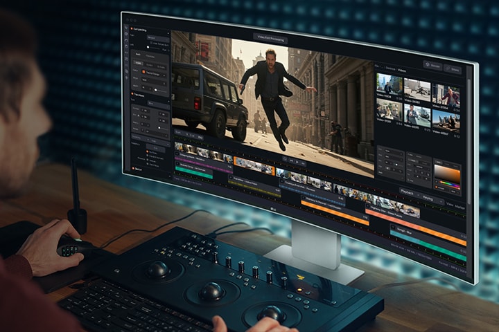 男性がUltraFineモニターに映る動畫作成プログラムで作業をしている。