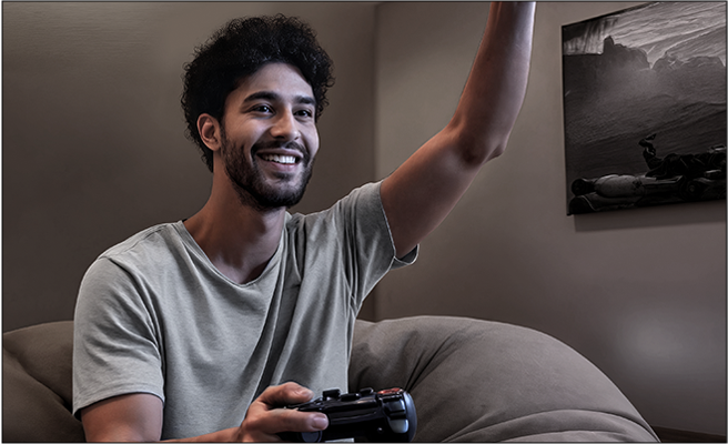 Felipe disfrutando videojuegos en un televisor OLED en la sala de juegos creada a través de la consultoría del hogar