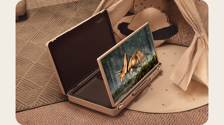 El estuche de la televisión LG StanbyME Go está abierto y la pantalla está desplegada. Dos ni?os en casa en un campamento improvisado con una tienda y luces cálidas y acogedoras. Están viendo un video en la pantalla de la StanbyME Go.