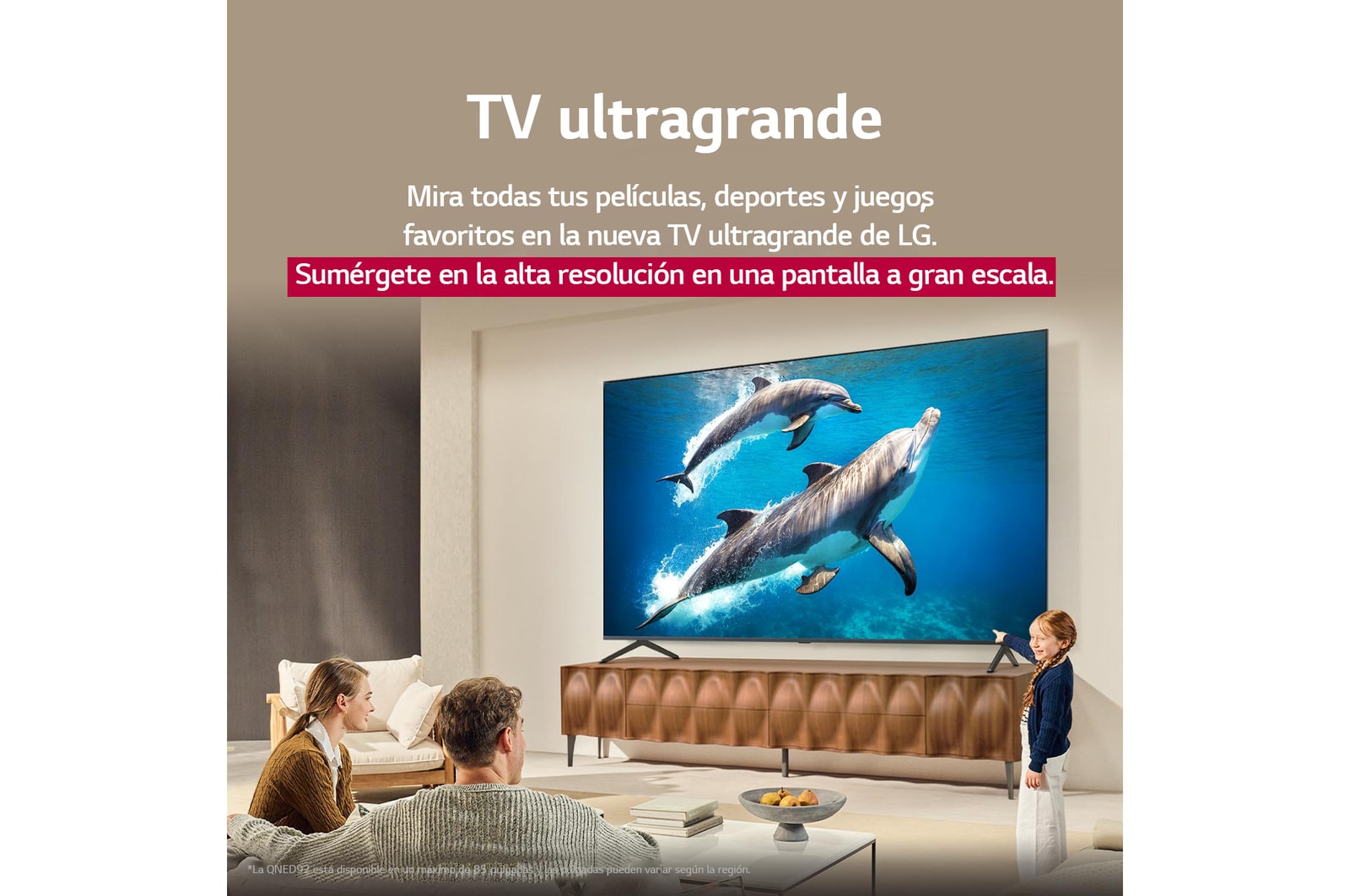 Una familia sentada en el sillón frente a una LG QNED TV situada sobre un soporte de televisión; una peque?a ni?a se?ala la pantalla que muestra dos delfines. El título habla de cómo puede disfrutar de la alta resolución en una pantalla gigante.