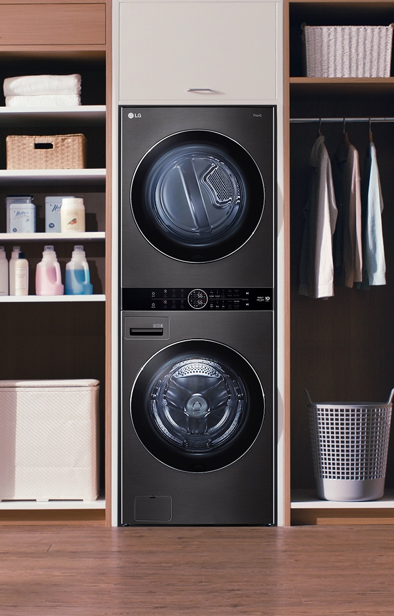 A black LG Wash Tower is installed with shelving and a closet in a wall unit.