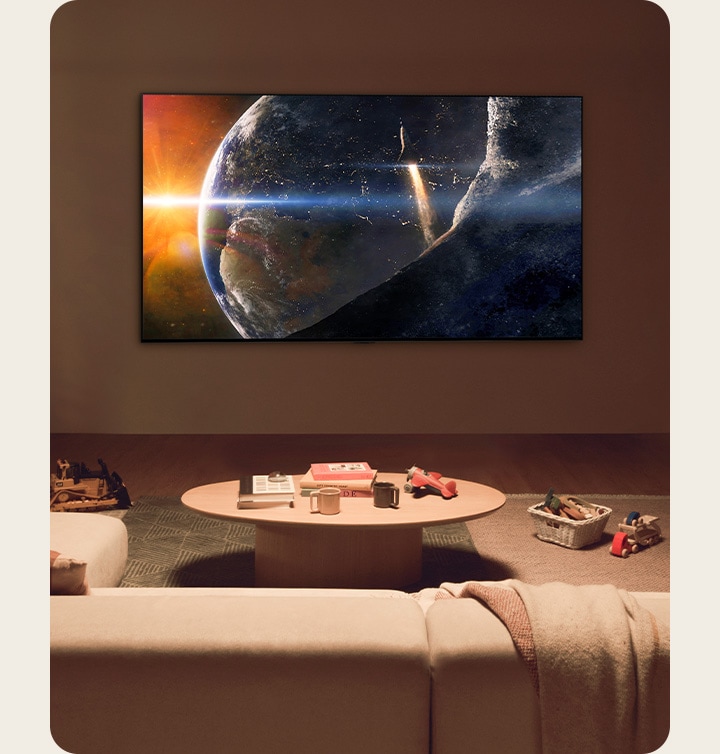 Una familia estaba sentada en el suelo de una sala poco iluminada junto a una mesa peque?a, mirando un televisor LG montado en la pared que mostraba la Tierra desde el espacio.