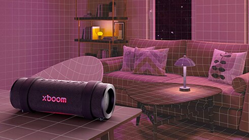 The LG xboom is placed on a living room table surrounded by furniture.
