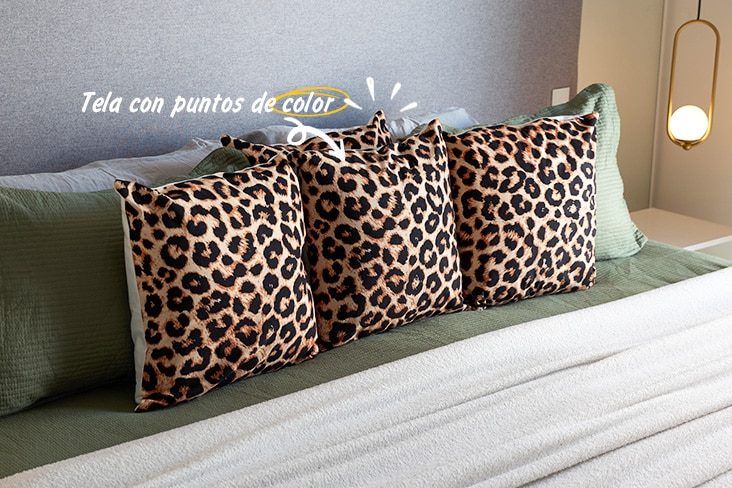 Cojines con estampado de leopardo sobre la cama.