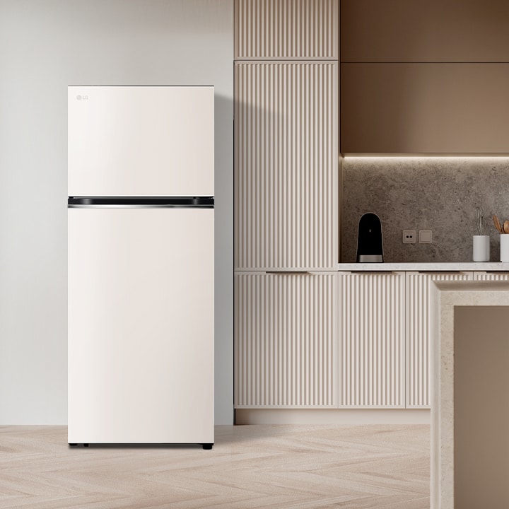 Refrigeradora LG de dos puertas color blanco, ubicada en una cocina moderna con gabinetes beige y encimeras de mármol.