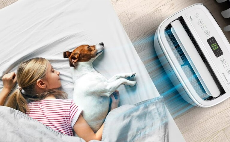 Una ni?a y su perro disfrutando del Aire Acondicionado Portátil LG