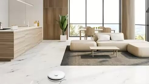 A blue light glows from the top of the LG CordZero? as it scans the living room floor with its LiDAR sensor.