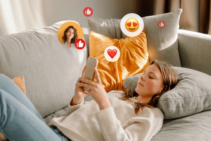 A young woman wearing a white sweater and jeans is lying on a sofa, liking her friend's post on social media with her phone.