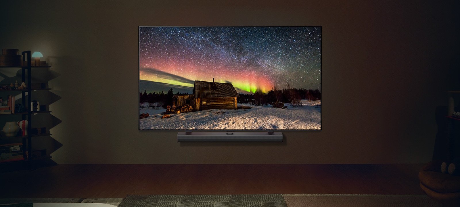LG TV i LG Soundbar w nowoczesnej przestrzeni w nocy. Obraz zorzy polarnej wy?wietlany jest z idealnym poziomem jasno?ci.