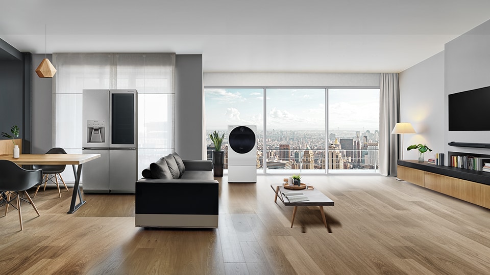 LG SIGNATURE Lodówka, pralka i telewizor OLED W s? wy?wietlane w salonie z widokiem na miasto za oknem.