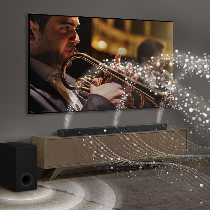 LG TV, LG Soundbar i subwoofer w nowoczesnym, miejskim apartamencie. LG Soundbar emituje fale d?wi?kowe sk?adaj?ce si? z bia?ych kropelek wype?niaj?cych pomieszczenie, a subwoofer tworzy efekt d?wi?kowy wydobywaj?cy si? z do?u. Razem tworz? efekt kopu?y w ca?ym wn?trzu.