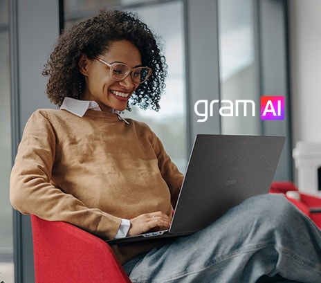 Das Bild zeigt eine l?chelnde Frau, die in einer modernen, gemütlichen Umgebung an einem Laptop sitzt. Der Text lautet: ?Dein eigener KI-Sekret?r“ neben dem ?gram AI“-Logo, das die KI-gestützten Assistenzfunktionen des Ger?ts hervorhebt.